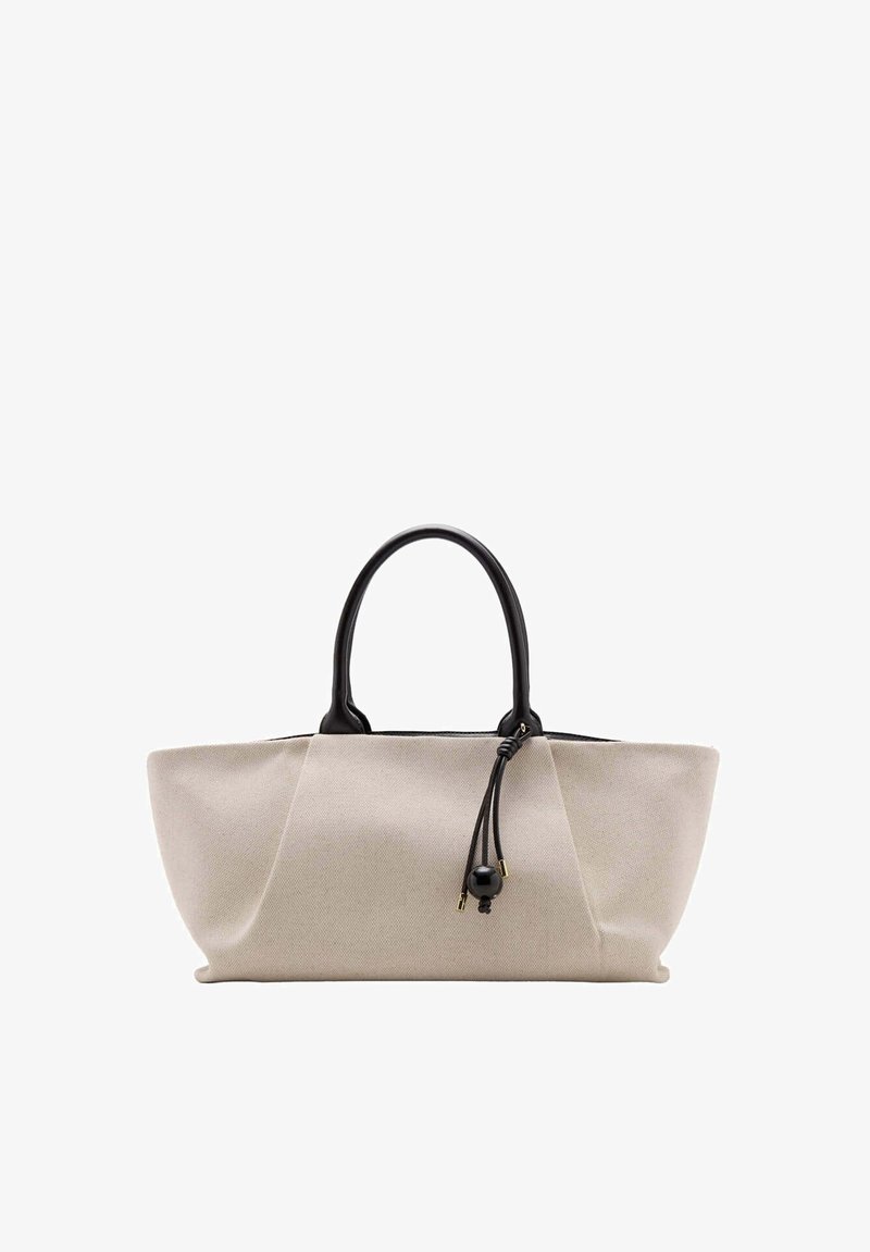 Sac fourre-tout en tissu beige avec une structure souple, des poignées noires arrondies et un cordon noir avec détail de perles suspendu près des poignées.