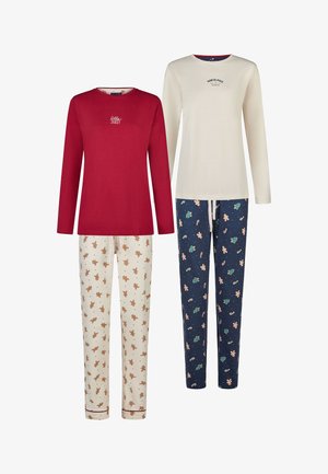 Rood shirt met lange mouwen en de tekst "Jolly", gecombineerd met crème en marineblauwe pyjamabroek met peperkoek- en feestpatronen. Zachte katoenen stof.