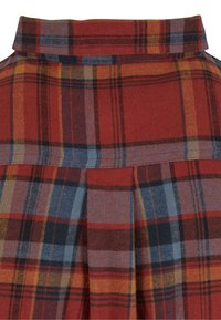 Red plaid fabric with blue, yellow, and black lines. Features a pleated design and a high collar at the neckline. Soft texture.