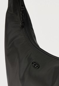 Svart skulderveske i nylon med en buet form, utstyrt med glidelås og en liten svart logo på siden. Glatt tekstur.