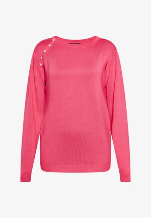 Vaaleanpunainen pitkähihaisella neuleella, joka on valmistettu pehmeästä neulekankaasta. Neuleessa on pyöreä pääntie ja koristeelliset napit olka-sauman varrella.