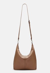 Sac en cuir marron avec une bandoulière réglable, des fermoirs en argent et une discrète embossage de marque sur fond blanc uni.