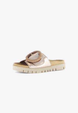 Slide sandal with beige sole, metallic rose gold strap, and large round beaded buckle on a white background.