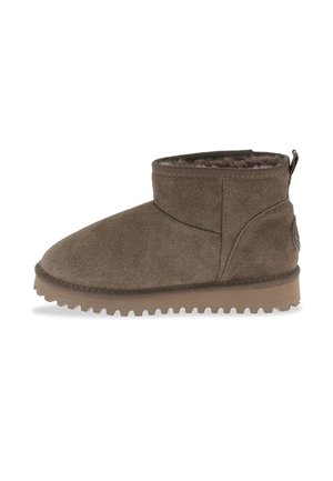 Stivale alla caviglia in suede marrone con punta arrotondata, dettagli cuciti, interno morbido e suola in gomma con scanalature testurizzate.