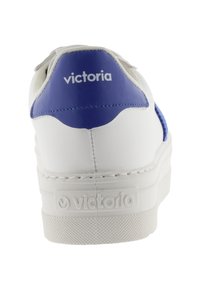 Sneaker bianco con un accento blu sul tallone, dotato di una tomaia liscia simile alla pelle e una suola in gomma testurizzata. Marchio "Victoria" sul retro.