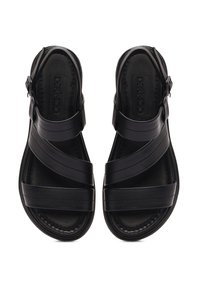 Black leather sandals featuring crisscross straps, open back, flat sole, and textured inner lining for comfort. Adjustable buckle detail.