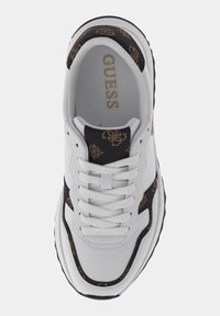 Sneaker bianco con accenti neri e marroni. Caratterizzata da una tomaia testurizzata, punta rotonda, lacci piatti e un logo sulla linguetta. Suola in gomma nera.