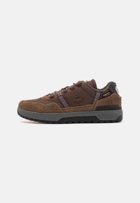 Braune Wildleder- und Textilsneaker mit einem strukturierten Design, grauer Gummisohle und gemusterten Schnürsenkeln. Mit Lacoste- und Cordura-Branding.