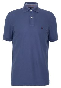Polo en coton bleu marine, avec une patte de boutonnage à trois boutons, des manches courtes et un petit logo sur la poitrine gauche.