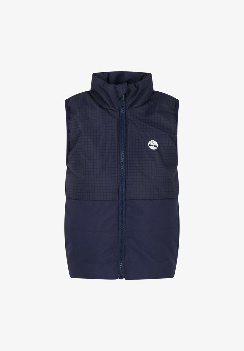 Veste matelassée sans manches bleu marine avec col haut, fermeture éclair intégrale à l'avant et logo arbre blanc sur la partie supérieure gauche de la poitrine.
