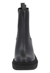 Czarna skórzana botka za kostkę o gładkim wykończeniu, płaskiej czarnej gumowej podeszwie oraz uchwytach po obu stronach dla łatwego zakładania.