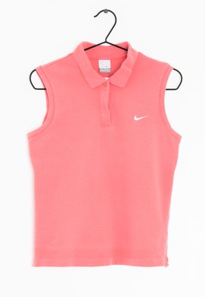Koszulka polo Nike w kolorze koralowo-różowym bez rękawów z dwoma guzikami i białym logo swoosh po lewej stronie na piersi, wisząca na czarnym wieszaku.
