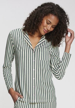 Striped pajama top in green and cream, featuring long sleeves, a lapel collar, a breast pocket, and pearl buttons. Soft fabric texture.