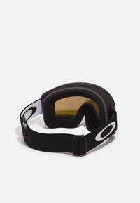 Svarta snöglasögon med linser i gult tint, mjuk skumisolering och ett svart elastiskt band med en vit logotyp.
