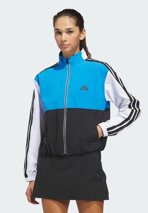 Niebiesko-biała i czarna wiatrówka z zamkiem błyskawicznym, elastycznymi mankietami oraz trzema czarnymi paskami na rękawach. Na piersi znajduje się logo Adidas.