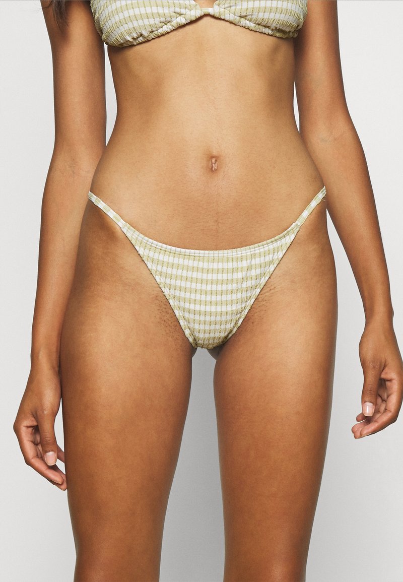 Bas de bikini jaune et blanc à rayures avec des bretelles fines et une finition texturée, présentant une coupe classique et une couverture minimale.