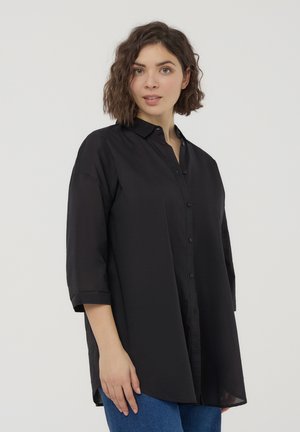 Camicia nera con colletto, maniche a tre quarti e vestibilità rilassata. Realizzata in tessuto liscio con una leggera lucentezza.