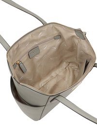 Grijze leren handtas met een ritssluiting, ruime binnenkant, beige voering met een subtiel logo-patroon, en een enkele schouderband.