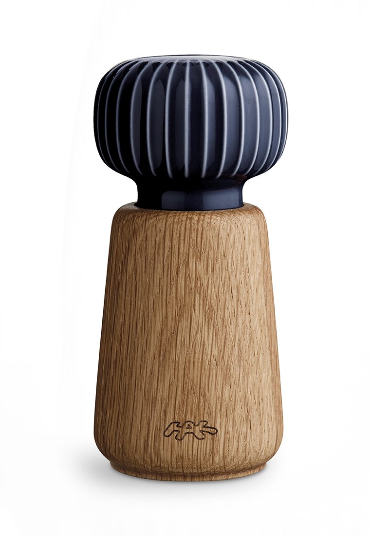 Drewniany młynek do pieprzu z żłobionym, ciemnoniebieskim obrotowym uchwytem i wygrawerowanym logo "HAY" na podstawie.