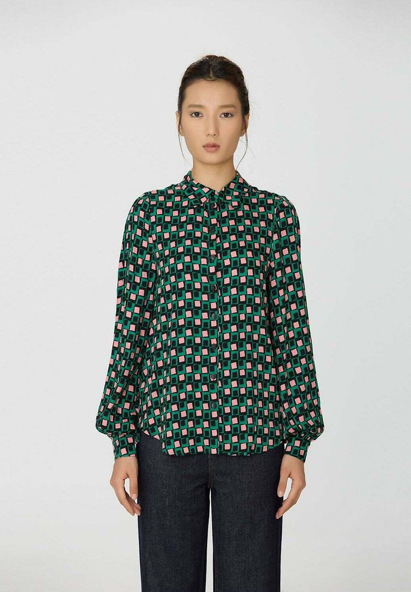 Chemise verte à boutons avec un motif géométrique en rose et vert foncé. Manches longues, coupe décontractée et design de col classique.