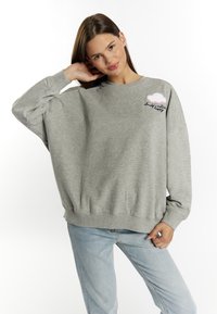 Felpa grigia chiara con scollatura rotonda, spalle cadute e design di nuvole ricamato. Tessuto misto cotone con una consistenza morbida.