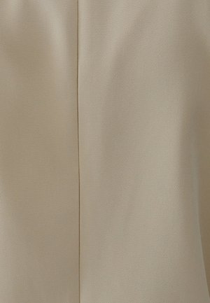 Beige stof med en glat tekstur, præget af en søm detail, der løber lodret. Materialet har et diskret vævemønster.