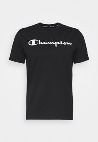 Černé bavlněné tričko s bílým logem "Champion" přes hrudník. Krátké rukávy a kulatý výstřih, hladká textura a klasický střih.