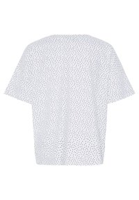 Biela krátka blúzka s čiernym nepravidelným vzorom bodiek, vo voľnom strihu a s okrúhlym výstrihom, zobrazená zozadu.
