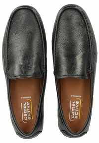 Black leather slip-on shoes with a textured surface, round toe, and brown insole, featuring subtle stitching and a logo detail.