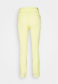 Pantalones de mezcla de algodón amarillos con corte Slim, que presentan dos bolsillos traseros y detalles de costura sutiles. Textura suave con un diseño de pierna recta.