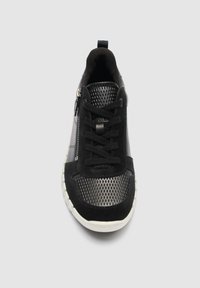 Melnas sporta apavi ar tīkliņa uzpurni, melnām šņorēm, sānu rāvējslēdzēju un baltu zoli, redzami no augšas uz gaiša fona.