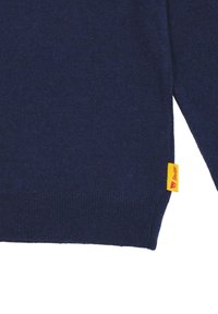 Maglione lavorato a maglia blu navy con una finitura texturizzata. Polsini e orlo a coste. Presenta un'etichetta gialla con il marchio sul lato.