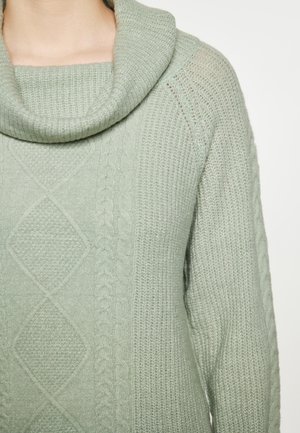Pulover cu guler închis de culoare verde deschis. Prezintă modele tricotate în cable și accente texturate. Material moale, cu o croială lejeră și cusături diagonale.