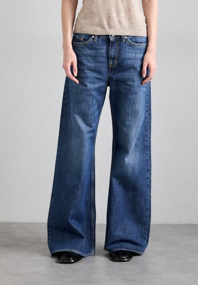 Wijde blauwe denim jeans met hoge taille, klassiek vijf-pocket ontwerp en zichtbare stiksels. Het materiaal heeft een lichte vervaging en een gladde textuur.