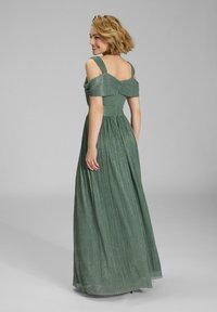 Robe maxi verte avec bretelles dénudées, en tissu texturé, corsage ajusté et jupe plissée, dotée d'une fermeture éclair dans le dos.
