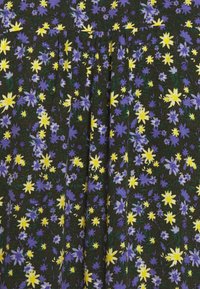 Svart tyg med ett blommönster i lila och gula blommor, med en strukturerad yta och veck för extra detalj.