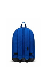 Sac à dos bleu de forme arrondie, fabriqué en tissu texturé. Il est équipé de bretelles rembourrées, d'une poignée supérieure et d'une base noire.