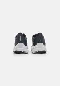 Donkerblauwe hardloopschoenen met een gestructureerde bovenkant, witte tussenzool en groene accenten. Voorzien van een duurzame zwarte rubberen loopzool en reflecterende details.