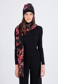 Musthave mustriline tooniline top, millele on lisatud lillemustriga must sall ja sobiv m�üts roosa ja punase aktsendiga. Pehmed, struktureeritud materjalid.