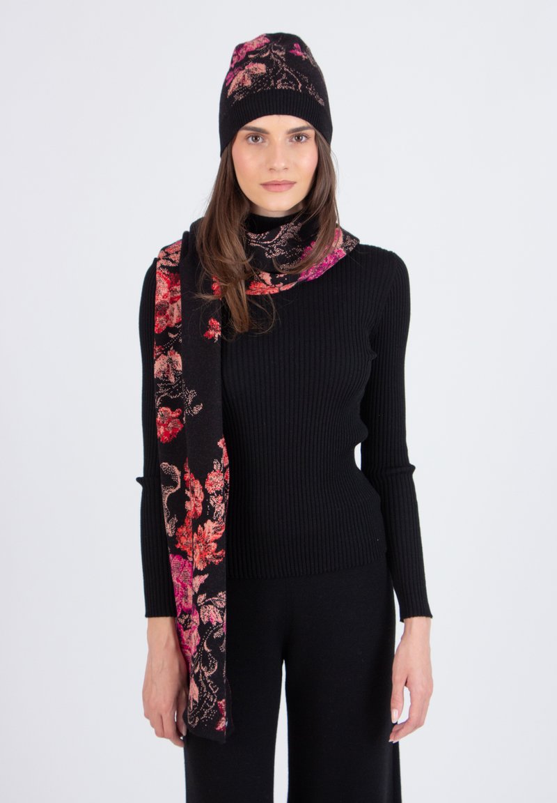 Musthave mustriline tooniline top, millele on lisatud lillemustriga must sall ja sobiv müts roosa ja punase aktsendiga. Pehmed, struktureeritud materjalid.
