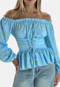 Jasnoniebieska bluzka z odkrytymi ramionami w żółty kwiatowy wzór, zebrana w talii z detalem wiązanym na sznurowadło i rozkloszowanymi rękawami, wykonana z lekkiego materiału.