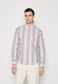 Camisa de botonadura stripada con rayas verticales en azul, rosa y blanco, que presenta un cuello, un bolsillo frontal y mangas con puños.