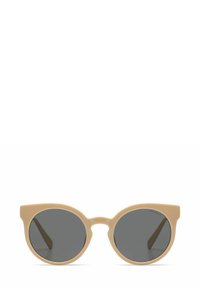 Lunettes de soleil rondes avec une monture en plastique beige et des verres gris. Présentent un design distinctif avec une légère forme d'œil de chat et des branches épaisses.