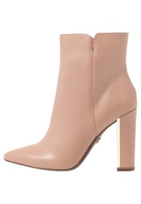 Różowe skórzane botki za kostkę z ostrym noskiem, wysokim słupkowym obcasem i złotym akcentem na obcasie. Gładka faktura, zamek błyskawiczny z tyłu.