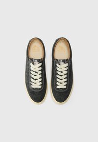Sneaker in denim nero con lacci e cuciture in avorio. Fodera color ocra e logo sulle solette. Punta arrotondata e suola in gomma a contrasto.