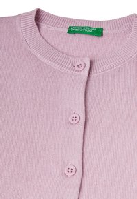 Světle růžový cardigan s kulatým výstřihem, zapínáním na pět knoflíků a měkkou pletenou texturou. Na štítku je napsáno "United Colors of Benetton."