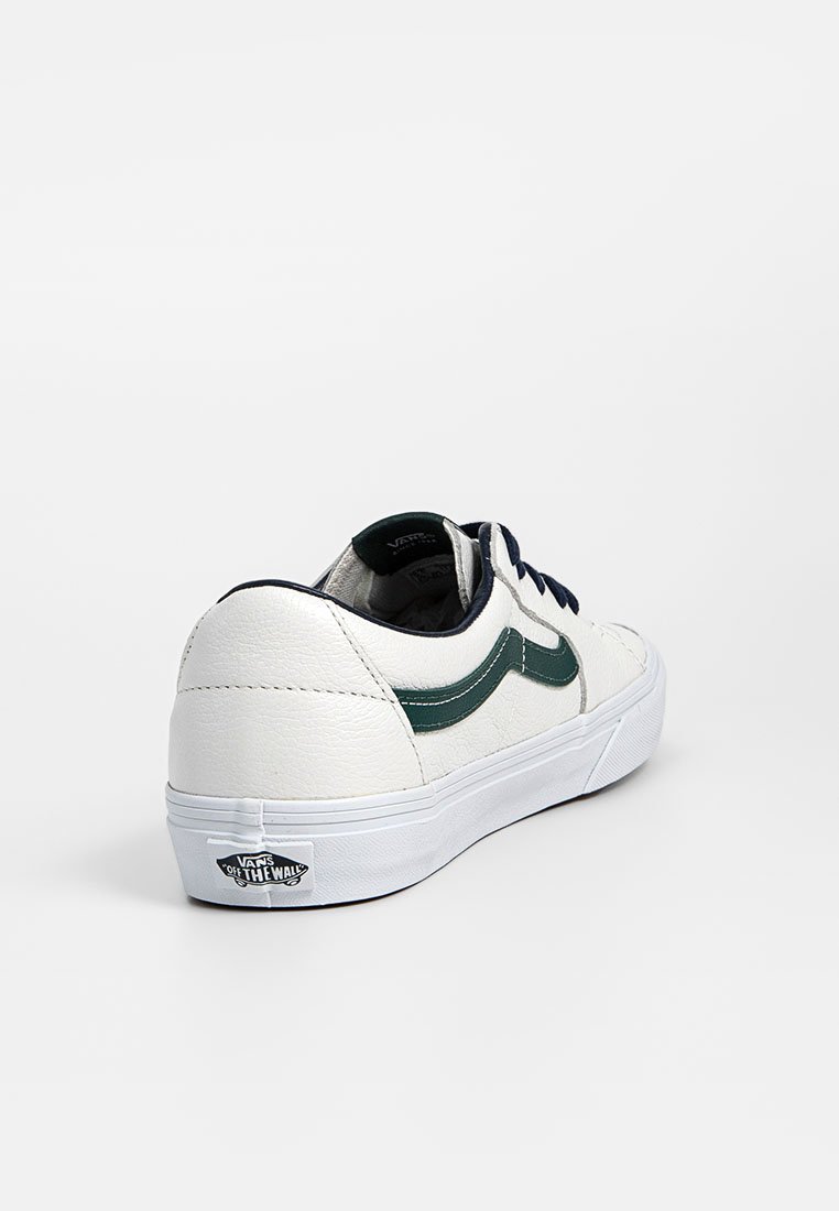 Weiße Vans-Sneaker mit grünem Seitenstreifen, schwarzen Schnürsenkeln und "Off The Wall"-Logo an der Ferse, von der Rückseite auf weißem Hintergrund gezeigt.