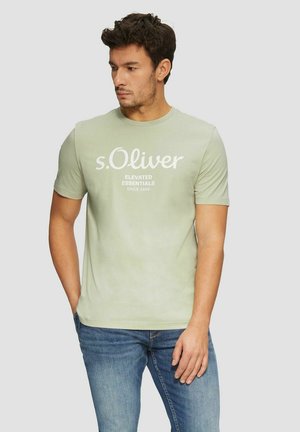 Light green cotton t-shirt with a crew neck, featuring white print reading “s.Oliver” and “ELEVATED ESSENTIALS SINCE 1969” on the front.