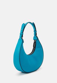 En turkos läderhandväska med en böjd siluett, försedd med en svart dragkedja och justerbar rem, med en slät yta.