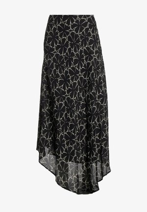 Jupe asymétrique noire avec grand imprimé floral blanc et tissu fluide, légèrement transparent.